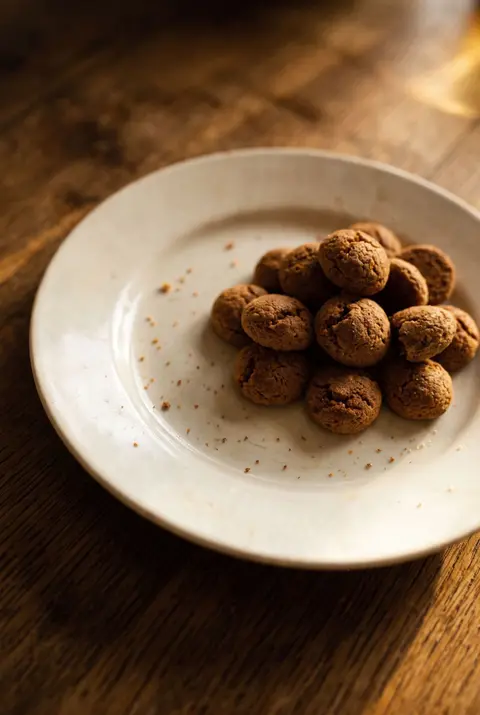 A small heap of pepernoten on a white plate