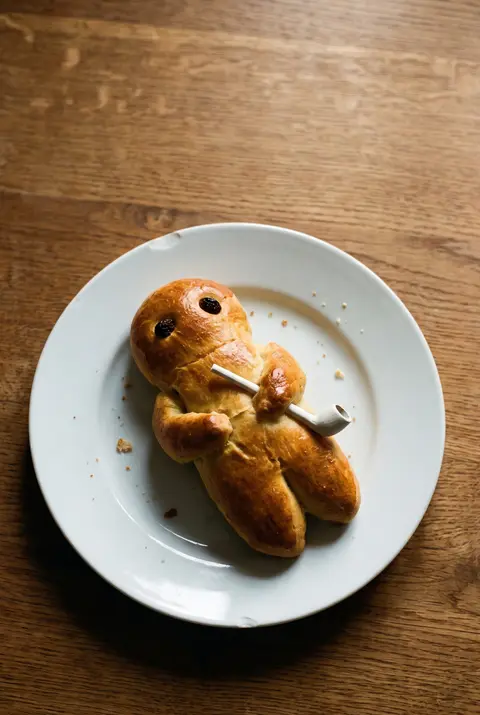 A golden bakery Weckmann on a white plate