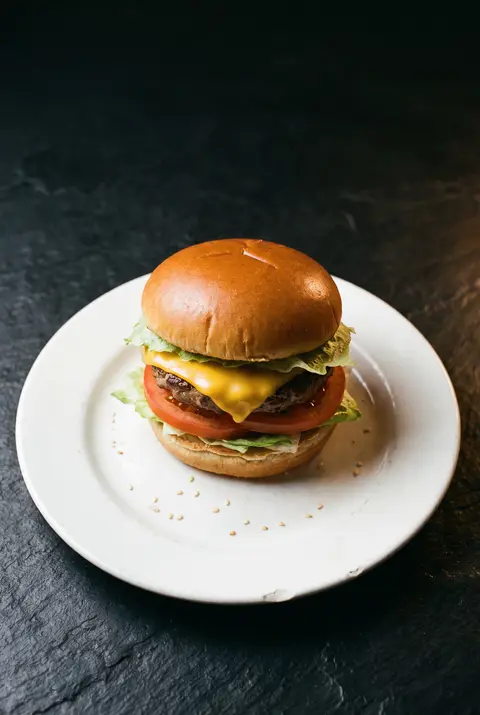 A restaurant cheeseburger with melted cheese on a white plate