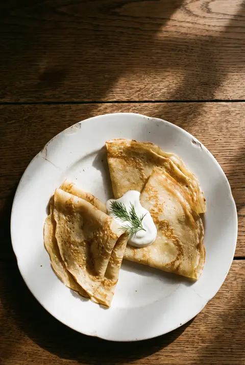 Three thin blini on a white plate