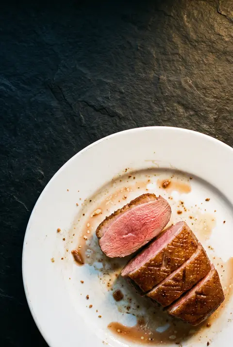 A duck breast on a white plate