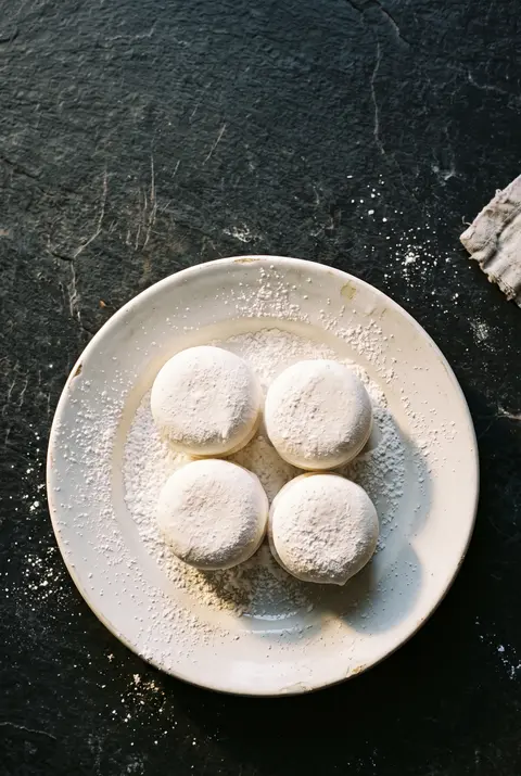 Four big white marshmallows on a white plate
