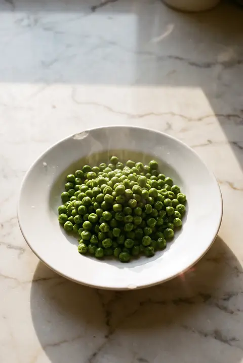 A portion of green peas on a white plate