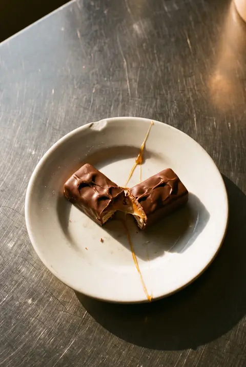 A chocolate bar with nougat and caramel on a white plate