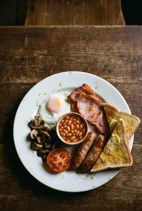 A full English breakfast with fried egg on a white plate