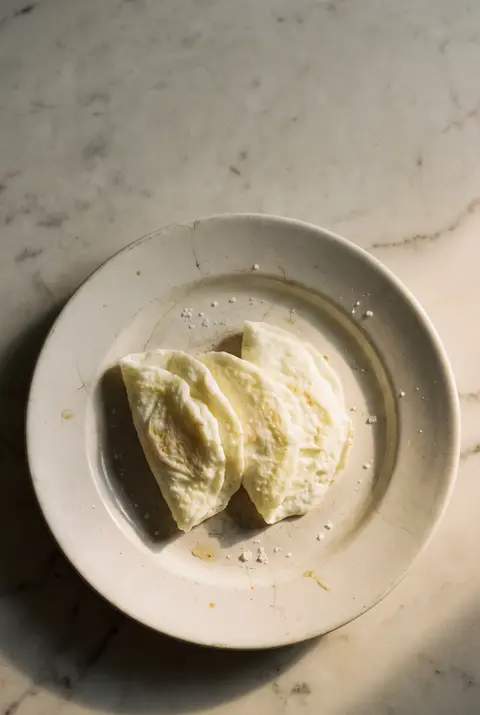 Three cooked egg whites on a white plate