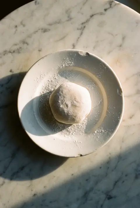 A plain white mochi rice cake on a white plate