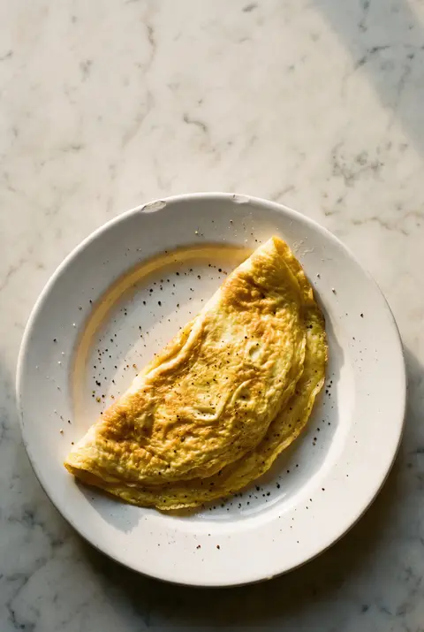 A plain three egg omelette on a white plate