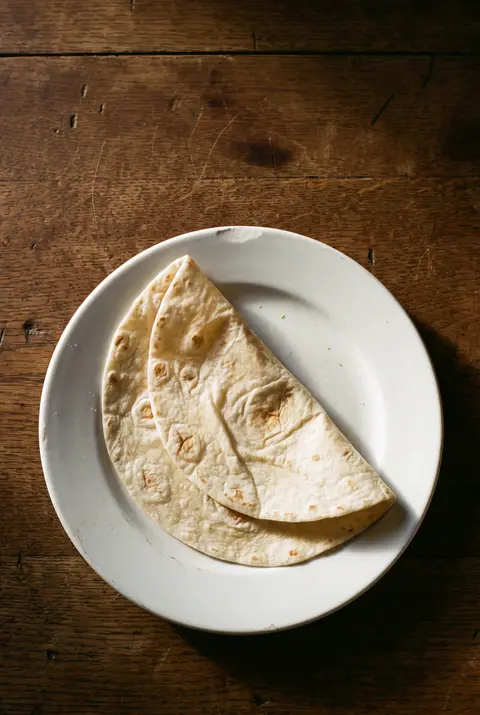 A plain flour tortilla wrap on a white plate