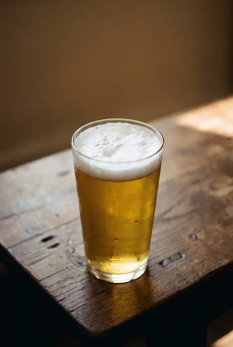 Half a litre of pale lager with a thick white head in a beer glass