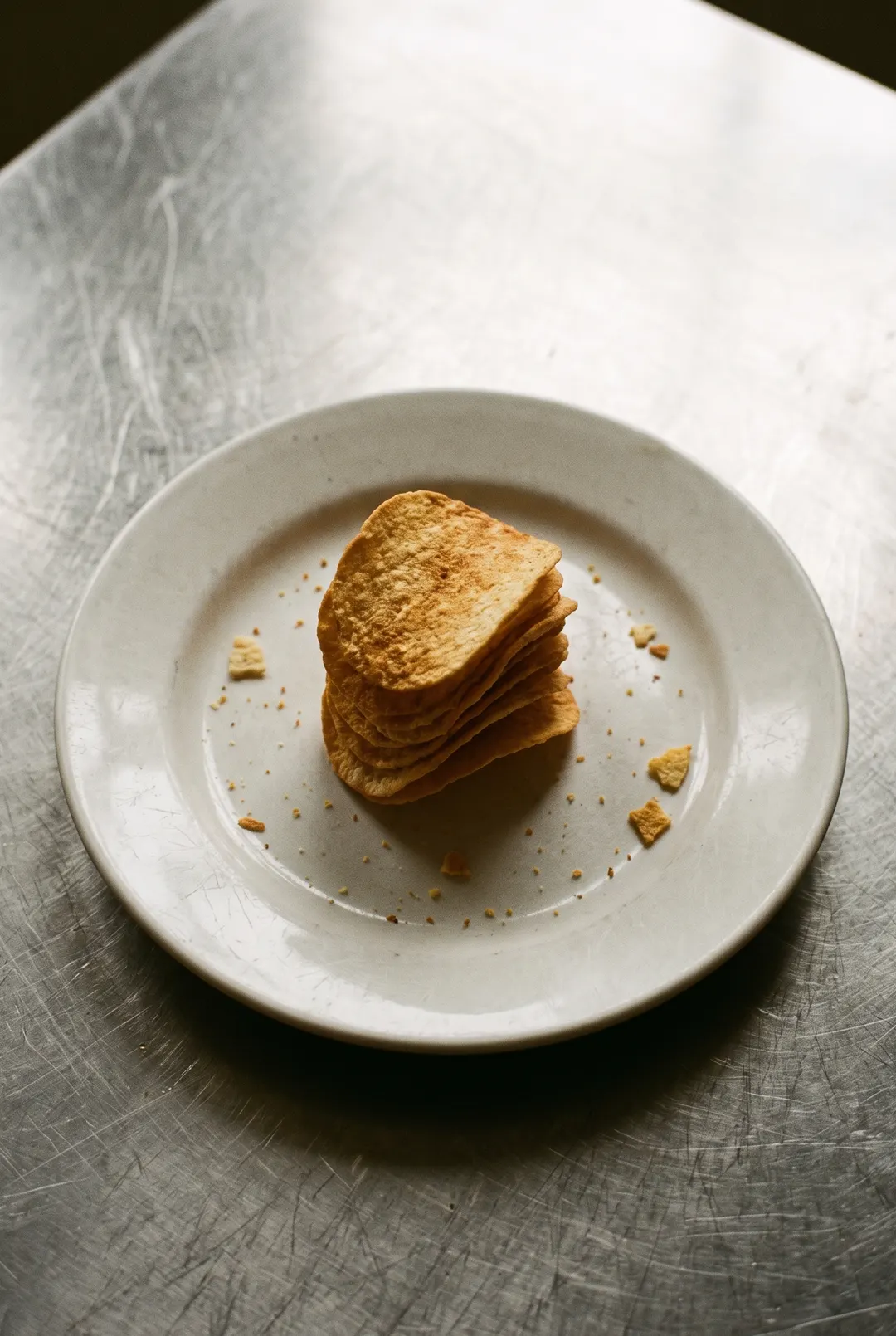 A small stack of saddle shaped potato crisps on a white plate