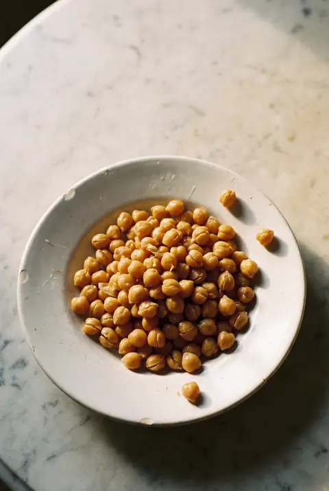 A portion of cooked chickpeas on a white plate