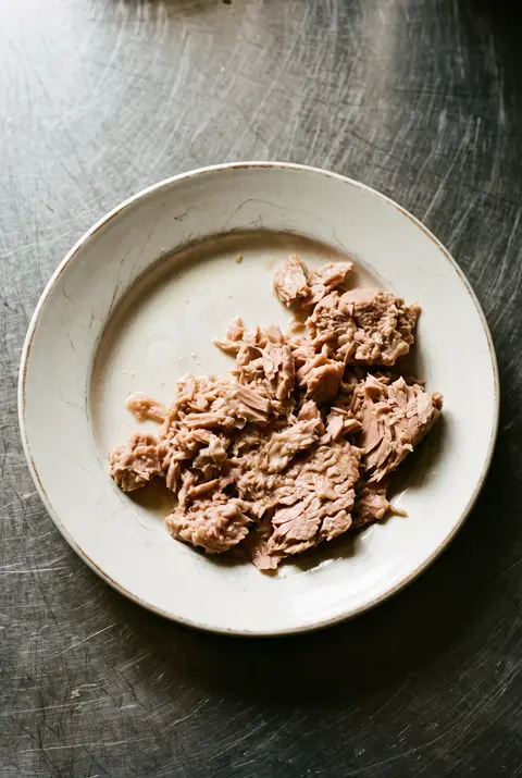 Tuna, about 100 g, on a white plate