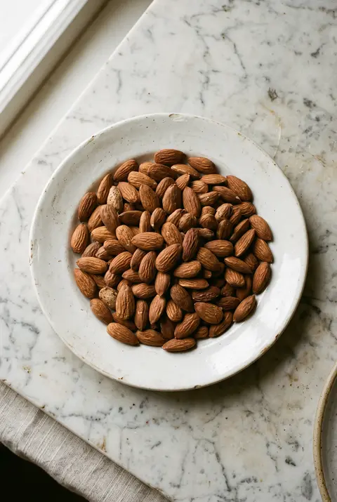 Almonds, about 100 g, on a white plate