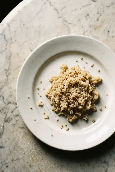 Quinoa, about 100 g, on a white plate