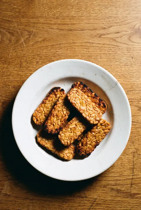 A portion of fried tempeh slices on a white plate