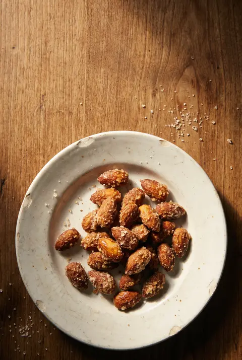 A small heap of sugar roasted almonds on a white plate