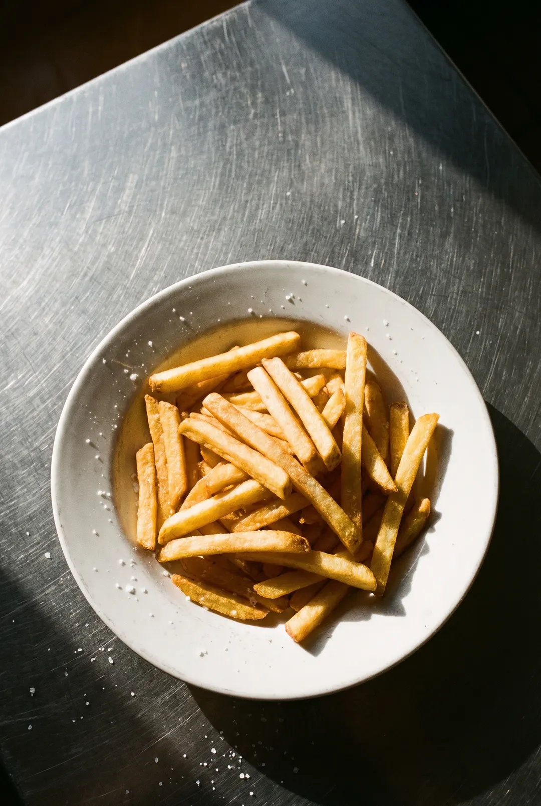 A medium portion of golden fries on a white plate