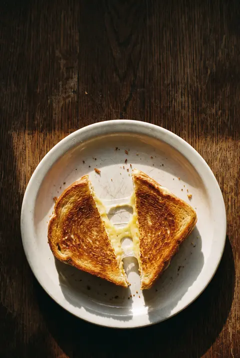 A grilled cheese sandwich cut in half on a white plate