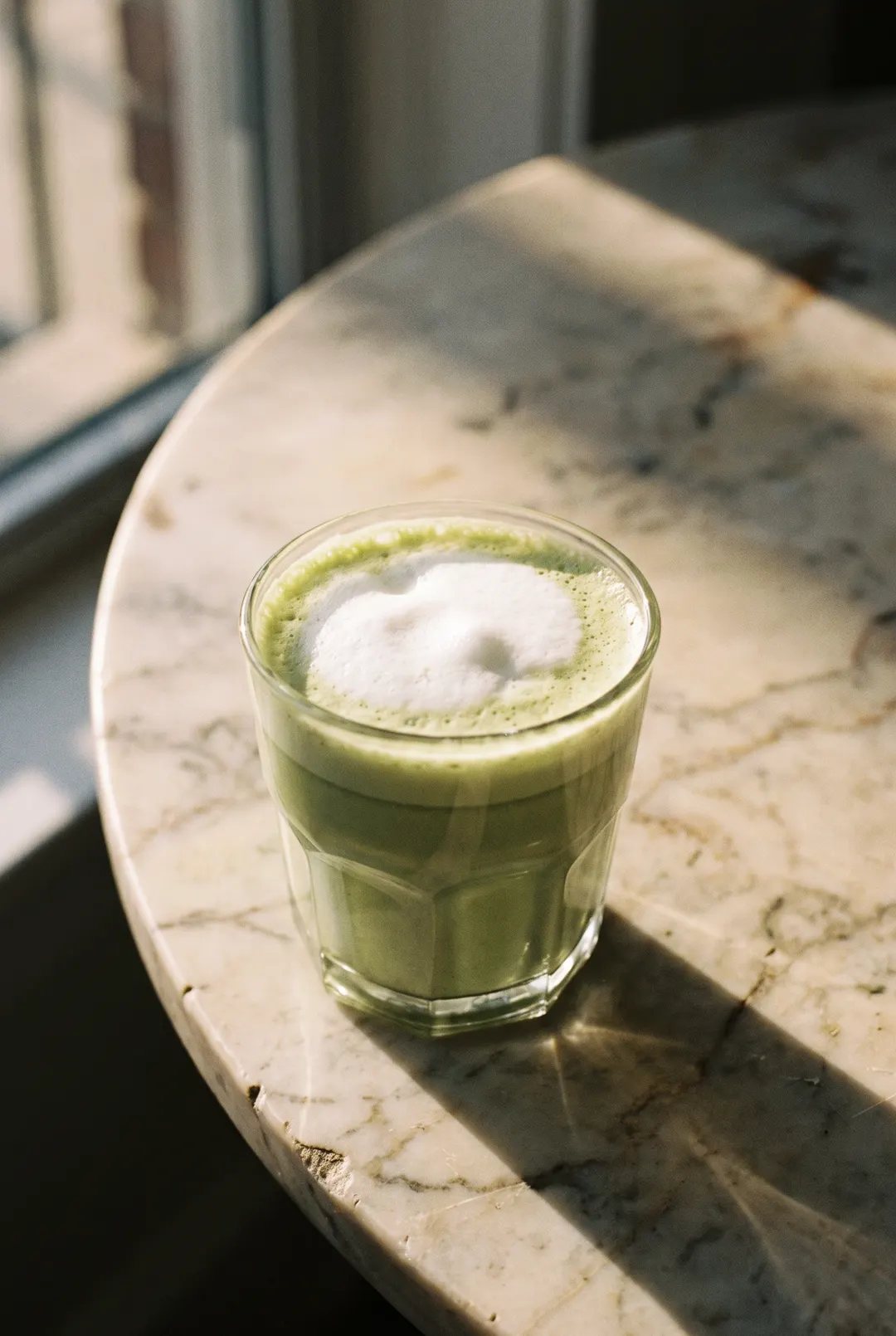 A matcha latte in a clear glass