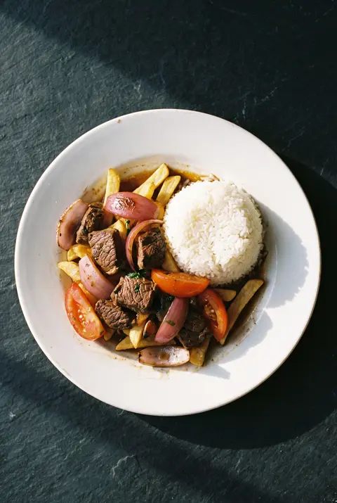 A plate of lomo saltado on a white plate