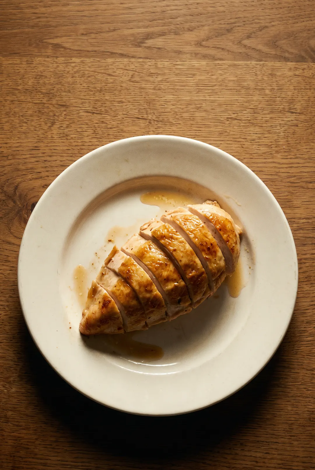 A cooked chicken breast fillet on a white plate
