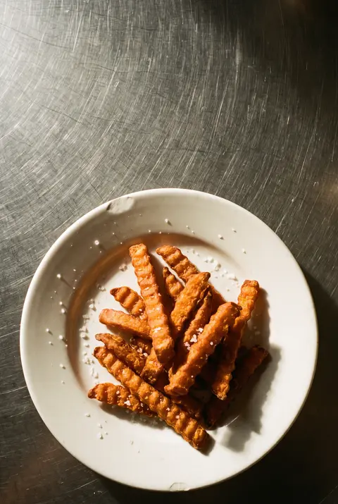 A side portion of sweet potato fries on a white plate