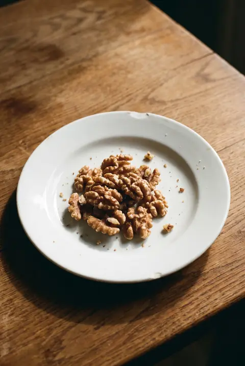 A small heap of walnut halves on a white plate