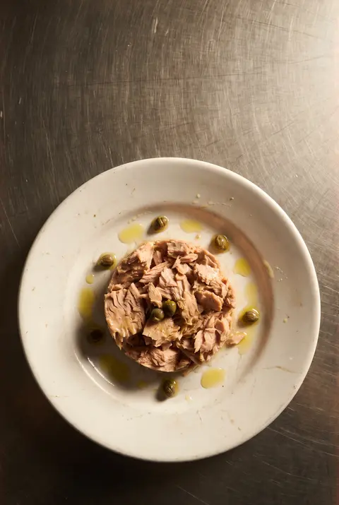 A tin of tuna in water on a white plate