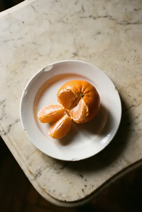 A mandarin on a white plate