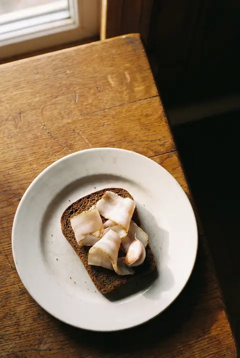 A few thin slices of salo on a white plate
