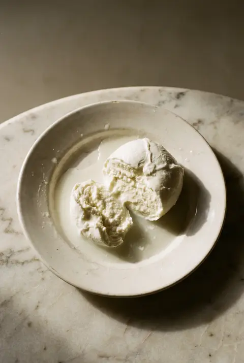 A ball of fresh mozzarella on a white plate
