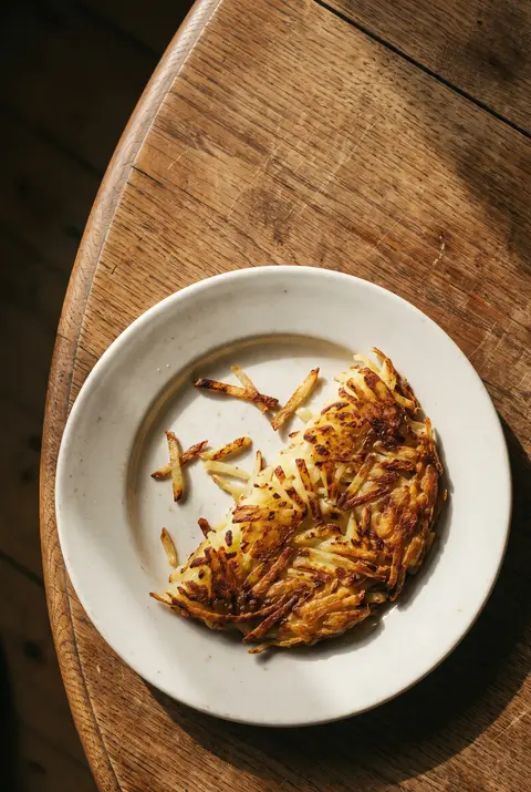 A portion of golden crisp rosti on a white plate