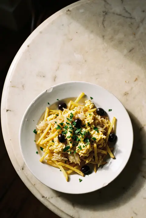 A plate of bacalhau a bras on a white plate