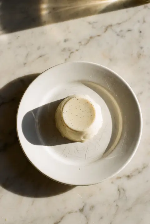 A panna cotta turned out of its mould on a white plate
