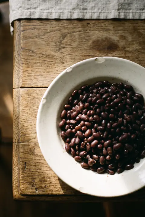 A portion of cooked black beans on a white plate